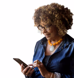 mulher de camisa azul olhando para a tela do celular